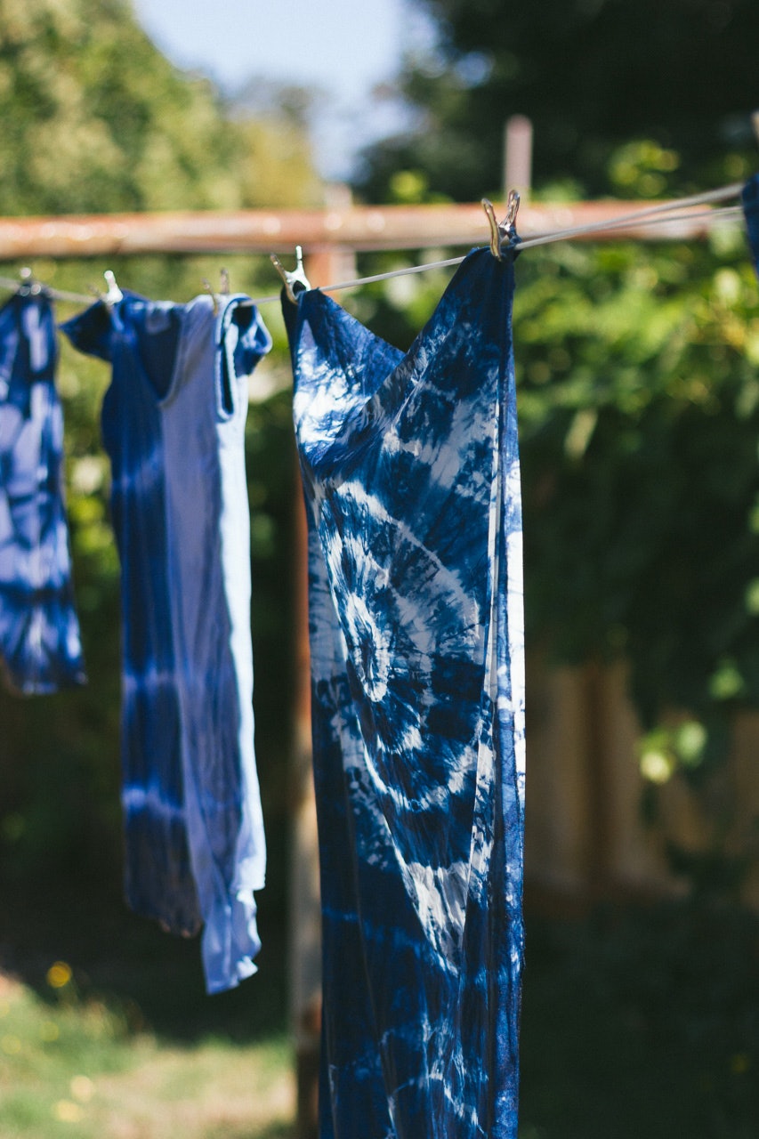 Shibori dyed linen hanging from line by Conscious by Chloé